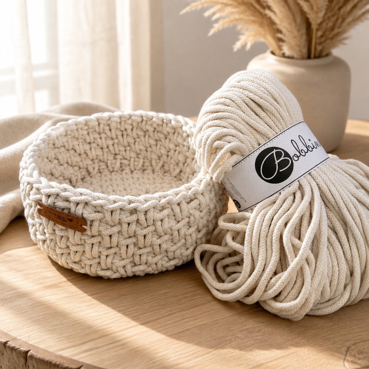 Crocheted storage basket in natural Bobbiny braided cord beside a ball of cord