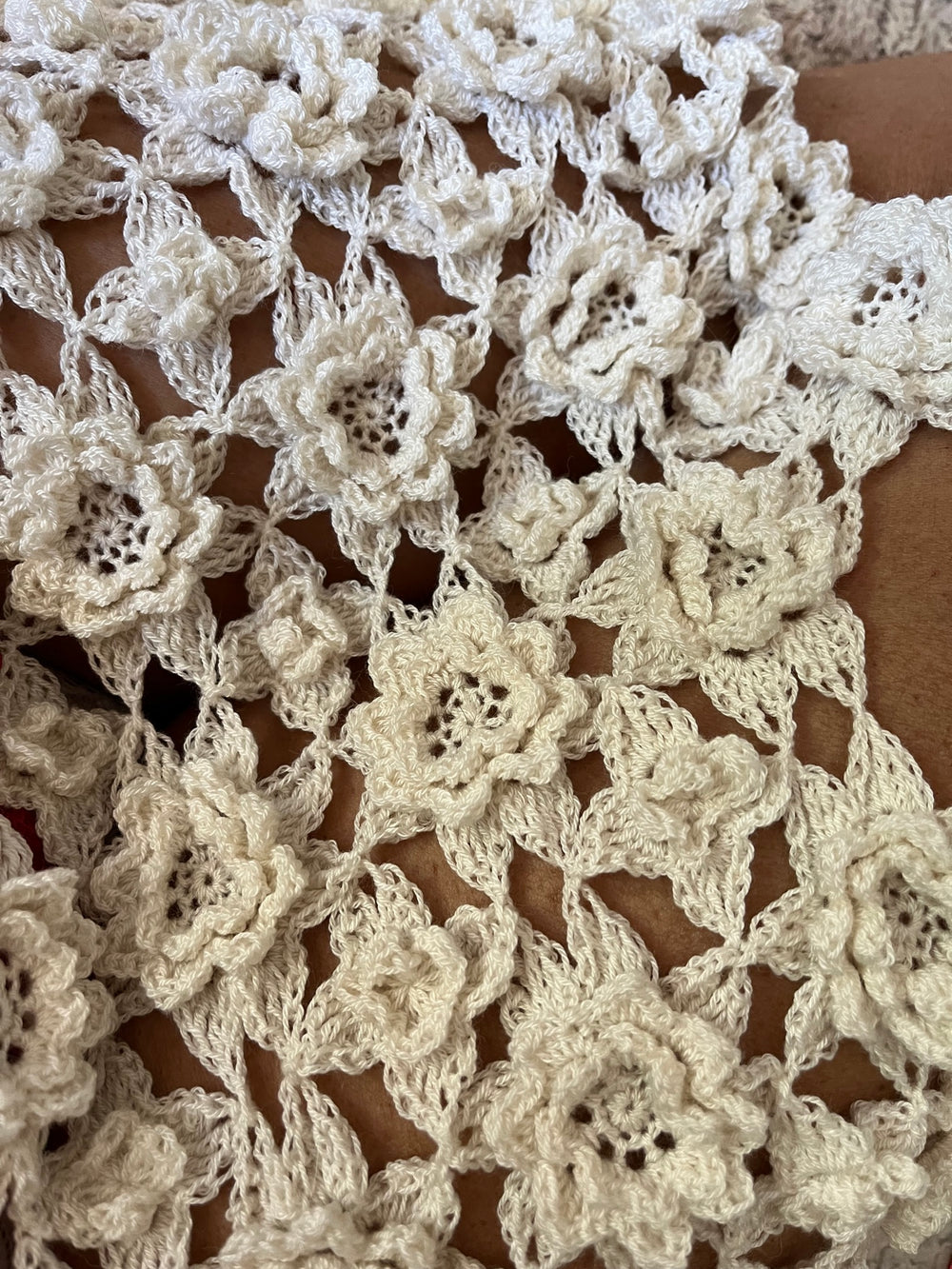 Close-up of an ecru crochet shawl made of joined flower motifs