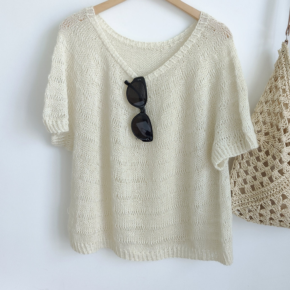 Short-sleeved top knitted in off-white Lotus Yarns Stars, on a hanger